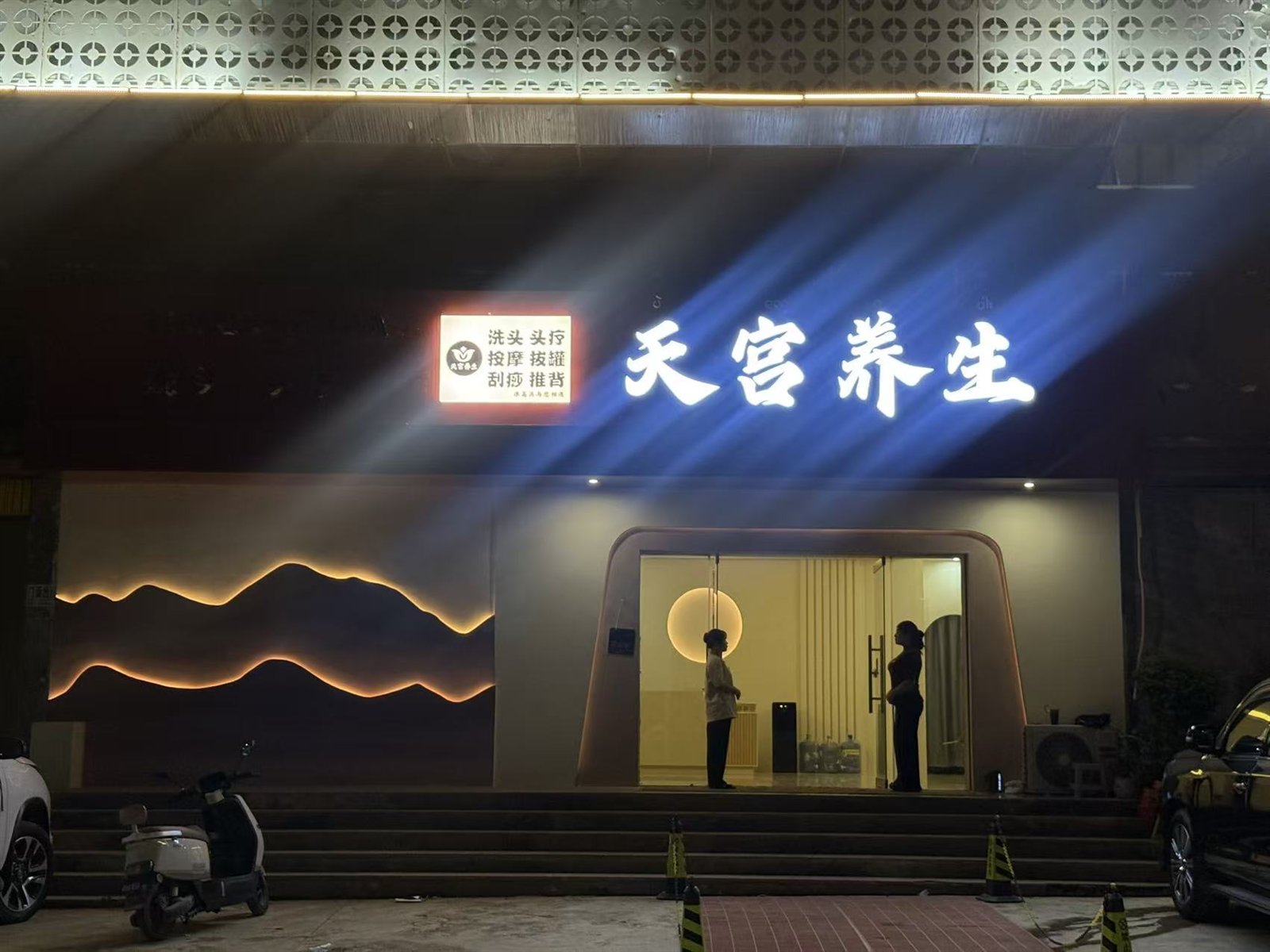夜晚灯光亮起后的天宫养生门店正面，店招清晰可见